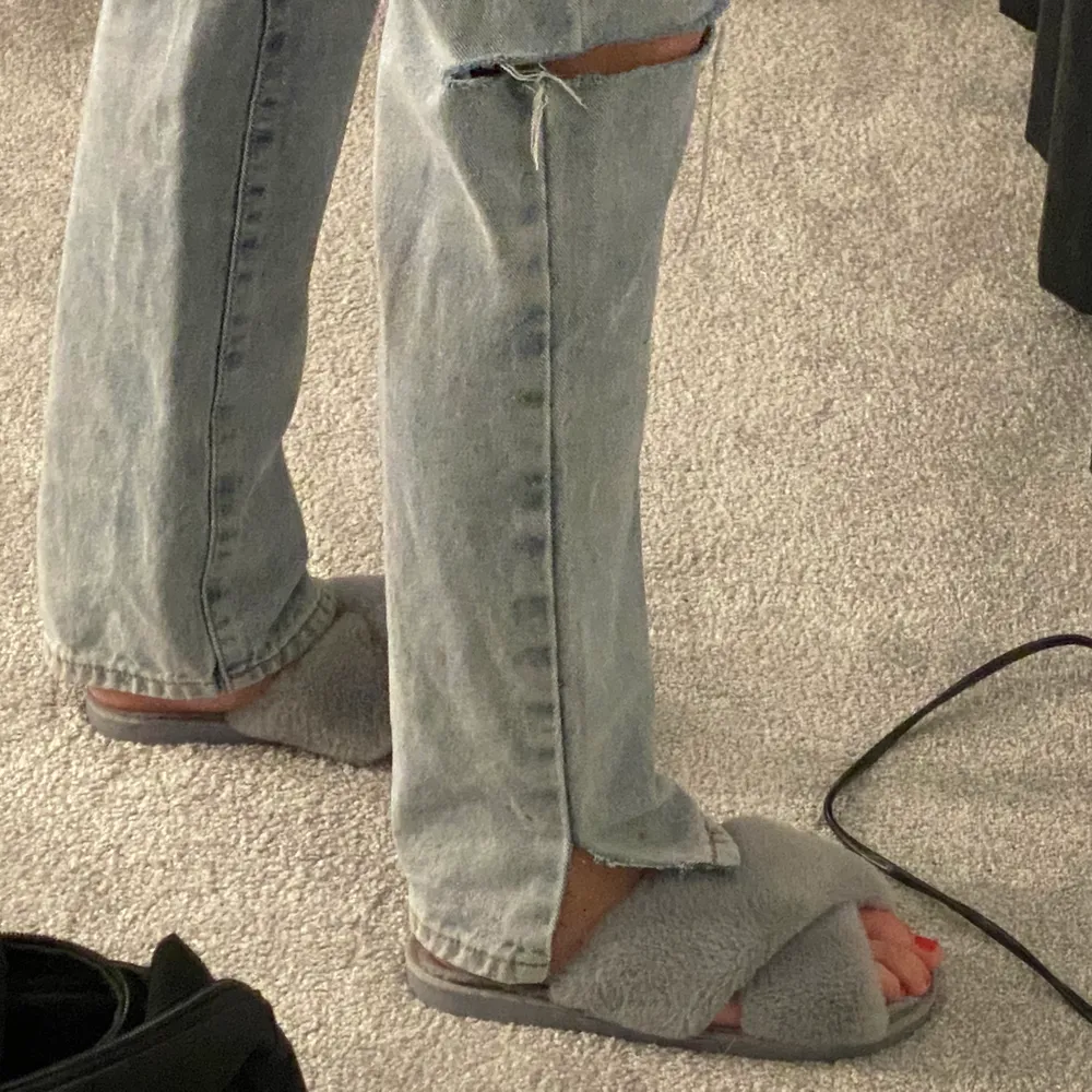 Blåa jeans med hål på knäna och små slitsar vid fötterna. Har en väldigt fin passform. Köparen står för frakten. Jeans & Byxor.