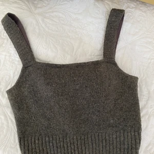 Stickad topp med kjol från hm  - Söt stickad topp och tillhörande kjol, strech material. Grönmelerad. Så gott som nytt då jag införskaffade mig endel andra set. Om fler är intresserade så blir det budgivning. 