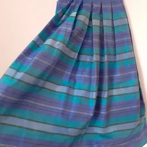 Vintage sikeskjol - Underbar längre kjol i 100% silke från Louise been st 38. Hittar ingen att anmärka på! Har en underkjol i ljusblått som är sytt med dubbelt tyg längst ner för extra stadga. Dragkedja samt knapp bak.  Midja 36 *2 Längd 88