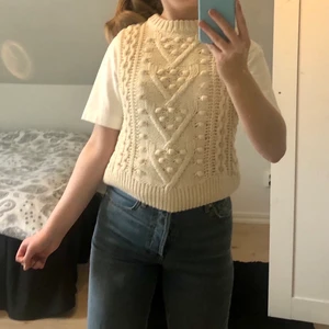 Väst  - Säljer denna stickade väst som jag själv gjort om (kommer från Gina, men jag har gjort om den då den egentligen tillhörde en blus). Köparen står för frakten! På bilden ser den ganska beige ut, men den är mer krämvit som på sista bilden. 