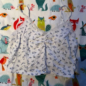 Vit croptop med blommor - Ett vitt linn/croptop med blåa blommor, jättesöt på sommaren med kjol annars bara skön att ha hemma