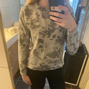 Grå tröja - Grå tröja med blomtryck, köpt på cubus i storlek xs.