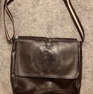 Diesel väska  - Nästan oanvänd axelremsväska i mörkbrunt skinn från Diesel. Väskan känns som ny då den inte har några defekter. Rymlig och i bra storlek! Skriv vid intresse☺️