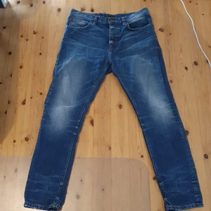 Nudie Jeans W33 L30 Mörk blå - Ett par mörk blå jeans från nudie jeans. Köpte dem för några månader sen men dem har bara legat i min garderob knappt använda.
