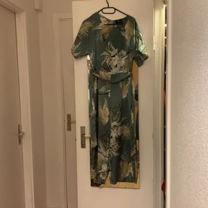 Jumpsuit blommönster strl 10 - Blommig ljusgrön/blå jumpsuit från AX Paris. Slutar lite ovanför anklarna på mig (173cmk), går att knytas i midjan och har fickor!! Finns i Lund 