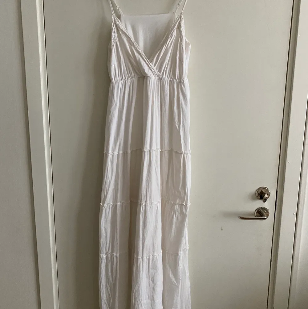 En vit, väldigt lång klänning med lite spets detaljer och annat, i storlek S. Eventuell frakt betalas av köparen . Klänningar.