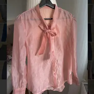A button down, see-through, pink, blouse  with tie at the front from shein, only used once.