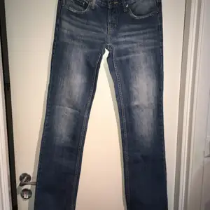 Lågmidgade, lite grann vida jeans från 7 For All Mankind, köpta begagnade. Fortfarande i bra skick. Innerbenslängden är ca 80 cm, midjan 78 cm och benbredden 36 cm. 