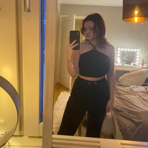 Svart topp med snörning - Säljer en kort topp med snörning och öppen rygg. Har klippt av lappen men tror den kommer från asos, endast använd 1-3 gånger. XS/S