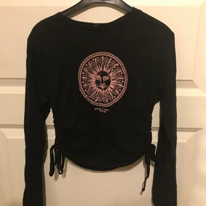 Sun topp - Svart topp med snörning på sidorna och Sol tryck fram från Urban outfiters. Stretchig storlek M