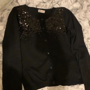 Svart tröja/ blus - En svart tröja/ blus med lite paljetter, köpt på hm för länge sedan men inte kommit till användning, inga fläckar eller skador. Det är en XS men S funkar också.