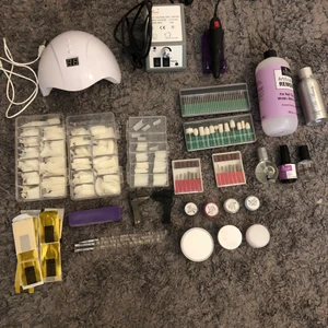 Nagelkit för egengjorda naglar - Ett superbra kit för att bygga egna naglar hemma. I kittet ingår:   *Elektrisk nagelfil med tillhörande filmunstycken  *Uv lampa  *Tippar i olika storlekar  *Akrylpulver *Akrylvätska  *3 borstar  *Nagelolja  *Activator och primer  *Formar för naglar  *Buffer *Vätska för borttagning av naglar  *2 Klämmor   Det rosa och blåa pulvret har lite klumpar i (se bild 3 och 4) men funkar alldeles utmärkt ändå.  Mycket bra skick (en del oanvänt) pris kan diskuteras, skriv vid intresse!