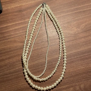 Pärlhalsband  - Ett underbart pärlhalsband med tre ihopsättande halsband med olika storlek på pärlorna. Perfekt för middag men även nån rolig tema fest. Underbart fint men har tyvärr inte kommit till användning, därav nyskick! Okänd märke, men köpt för 300kr, se bilder! (Frakt tillkommer utifrån priset