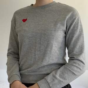 Fin gråmelerad sweatshirt i lite tunnare material med ett broderat hjärta. Tröjan är från H&M och är storlek xs. Den är näst intill oanvänd och i mycket bra skick. Köpare står för eventuell frakt.
