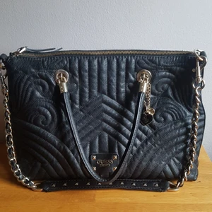 Guess väska - Guess väska inköpt på Le Printemps i Paris. Ursprungspris ca 1400 kr. Är i bra skick och inte sliten överhuvudtaget. Mått: 35 cm bred, 25 cm hög, 14 cm djup. DMa om du är intresserad! :)