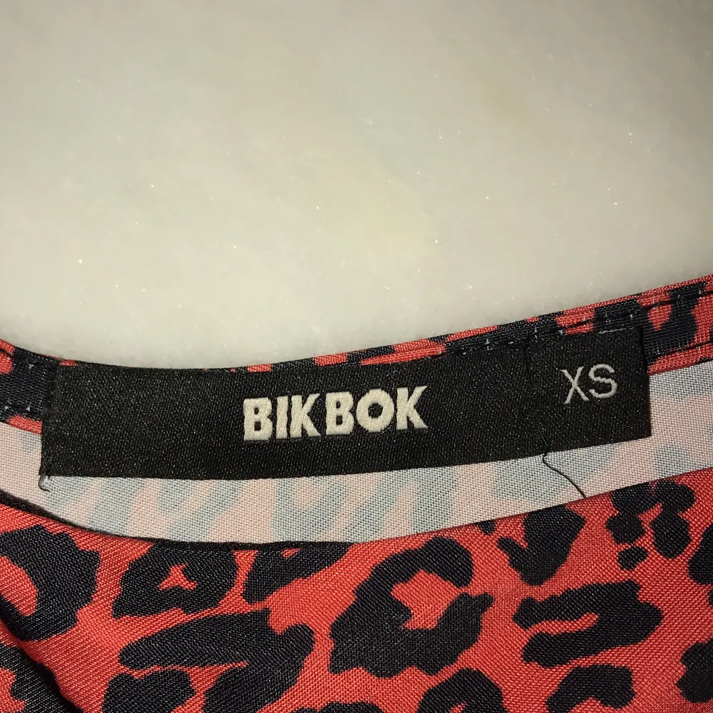 Säljer denna röda topp i leopard mönster från BikBok! Storlek XS! Aldrig använd! I fint skick!. Toppar.