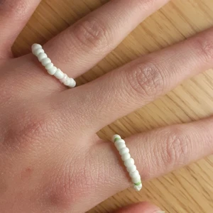 2st ringar, strl 1,4cm-1,5cm - Det är då 2st ringar i färgerna vit och rosa, vit och grön. Jag gör egna ringar, armband och halsband. Dem här ringarna har ingen använt tidigare. Det finns även i andra färger.