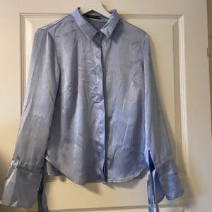 Blå blus/skjorta från NAKD storlek XS, passar även S, i satinliknande material. 