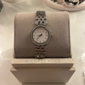 Michael Kors Klocka  - Säljer min superfina klocka i silver. Kommer tyvärr inte till användning längre. Superbra skick. Kan både spännas ut och in, passar de flesta. Säljer för 800kr 