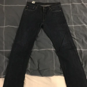 Mörk blåa Levis jeans storlek w34 l36 - Ett par Levis jeans i färgen mörk blå, i storlek midja 34 längd 36, använda för några år sen i bra skick mer bilder på byxorna kan skickas vid intresse(: vet inte vad frakten skulle bli men det kan jag skicka bild eller visa genom videochatt om det skulle behövas fraktas.
