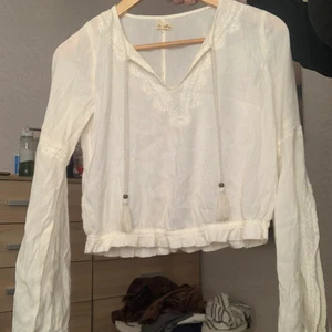 Söt vit topp - Så sött topp som är perfekt till sommaren, passa en s/xs och sälj då den tyvärr är för liten för mig. Så söta ärmar som är kluvna där fram, andra bilden.  På sitter den lite över naveln. Har även så söta detljer som syns lite på bilderna. Tröjan ser genomskinlig ut men en vit bh syns INTE under!💕💕