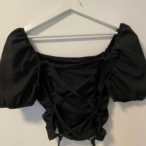 Topp med öppen rygg - Lite kortare svart topp med sicksackade snören i ryggen som gör att man kan gör den lite mindre eller lite större❣️ 