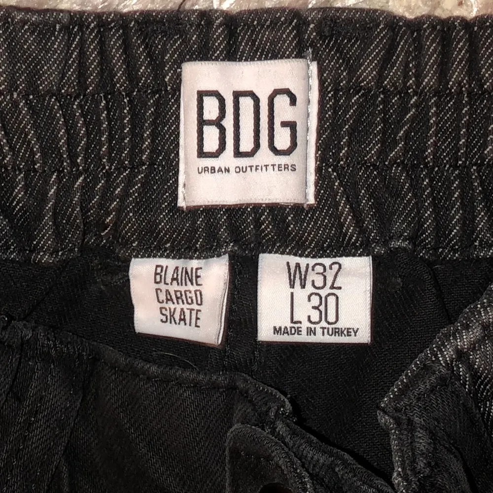 Ett par assnygga cargo jeans från Urban Outfitters (BDG) i två olika nyanser av svart jeans. Byxorna har skatestil och har en loose, wide passform. De har två stycken fickor på båda byxbenen och även vanliga i midjehöjd. På sista bilden kan man se måtten som är W32 och L30, passar M/L/XL beroende på vilken passform man vill ha :) (möjligtvis S). Säljer då de tyvvär är för stora:(. Jeans & Byxor.