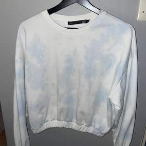 En croppad blå vit sweatshirt med tiedye effekt. Resår längst ner. Strl M, liten i storleken. 30 kr + 66 kr frakt = 96kr
