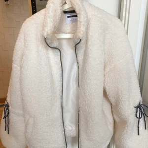 Vit teddyjacka från Noisy May - Fin vit teddyjacka med svartprickiga snören och detaljer. Knappt använd.