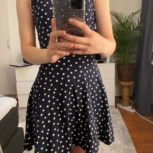 Prickig klänning  - En marinblå klänning med vita prickar i storlek 32 men passar mig som är 34/36. Klänningen är även fin att använda som en kjol med en tröja över 