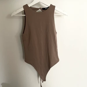 Body från BikBok med öppen rygg - Säljer denna helt oanvända bruna bodyn från BikBok i strl S. Säljer då jag tyvärr inte fått användning av den 💕 Odinarie pris: 299kr. Köparen står för frakt!!!✨
