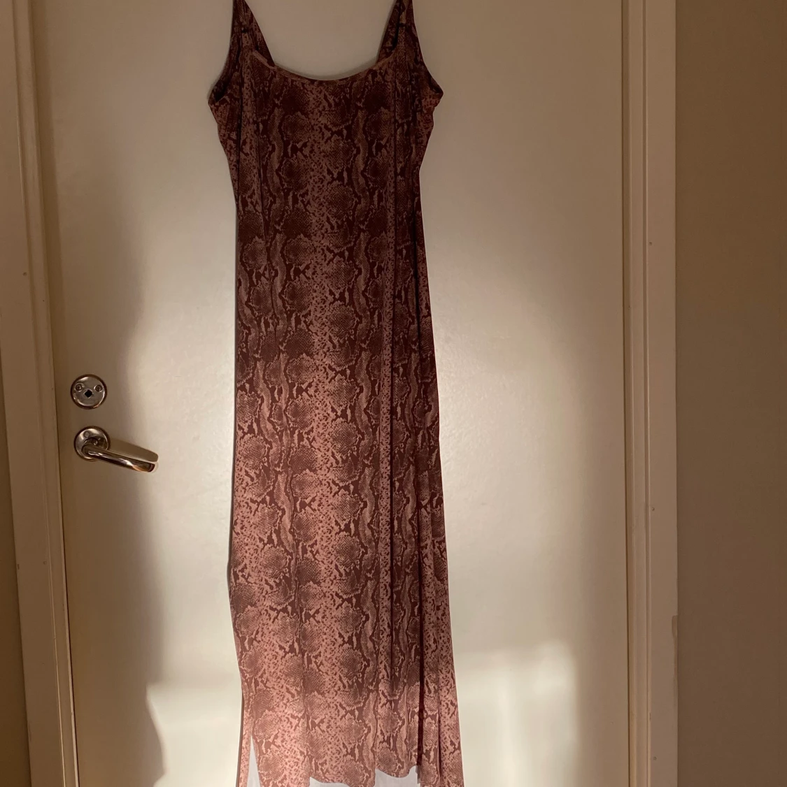 Ormmönstrad brun långklänning.