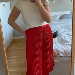 Röd plisserad kjol - Knälång plisserad kjol från Name it i strl 158 men passar perfekt om man är en XS eller S med. Så fin till midsommar eller andra härliga sommarfester. Bra stretch i midjan så känns inre för tajt.