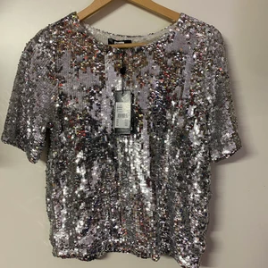 Paljett tröja - Silvrig paljett tröja från bikbok i storlek S. Helt oanvänd med lapp kvar, köpt för 399 säljs för 50kr. Frakt tillkommer