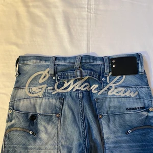 G-star jeans - Coola G-star jeans med tryck på rumpan. Köpte på Plick men har inte kommit till användning. Sitter lågmidjat och snyggt med en fin wash. Midjemåttet tvärsöver är 40 cm och innerbensmåttet 78,5 cm💕