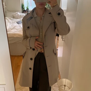 Beige Trenchcoat (oanvänd!!)  - Säljer denna SUPERFINA beiga trenchcoaten från Mark & Spencer med taggen kvar!! Det står ingen storlek på jackan, jag är en storlek S för referens:) 💞 köparen står för frakten men jag möter även upp i Lund💞 