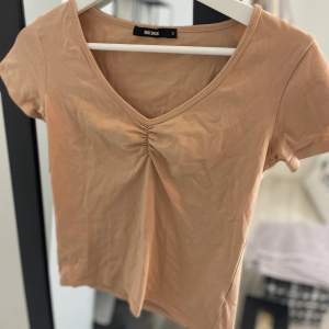 Ljusrosa/aprikos T-shirt från BikBok