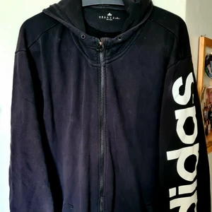ADIDAS hoodie med dragkedja 2xXL - Sparsamt använd Adidas hoodie med dragkedja pga att den är för stor för mig.  Storlek 2xXL. Svart med vit text "adidas" på vänster arm.  Det står även Adidas på själva luvan . För mer foton eller frågor,  kontakta mig  🙂