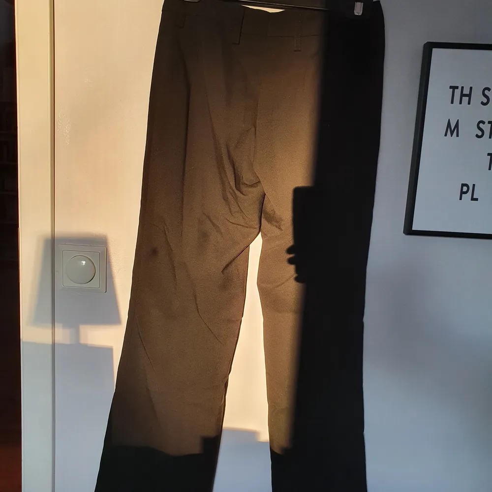 Svarta kavajbyxor i storlek 34. Svagt utsvängda ben och helt oanvända. Jeans & Byxor.