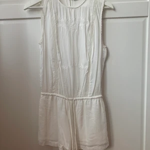 Somrig vit playsuit strl xs - Fin vit playsuit! Köpt från Zara. Väldigt fint skick. Använd en gång bara. Se gärna annat jag säljer också! :)