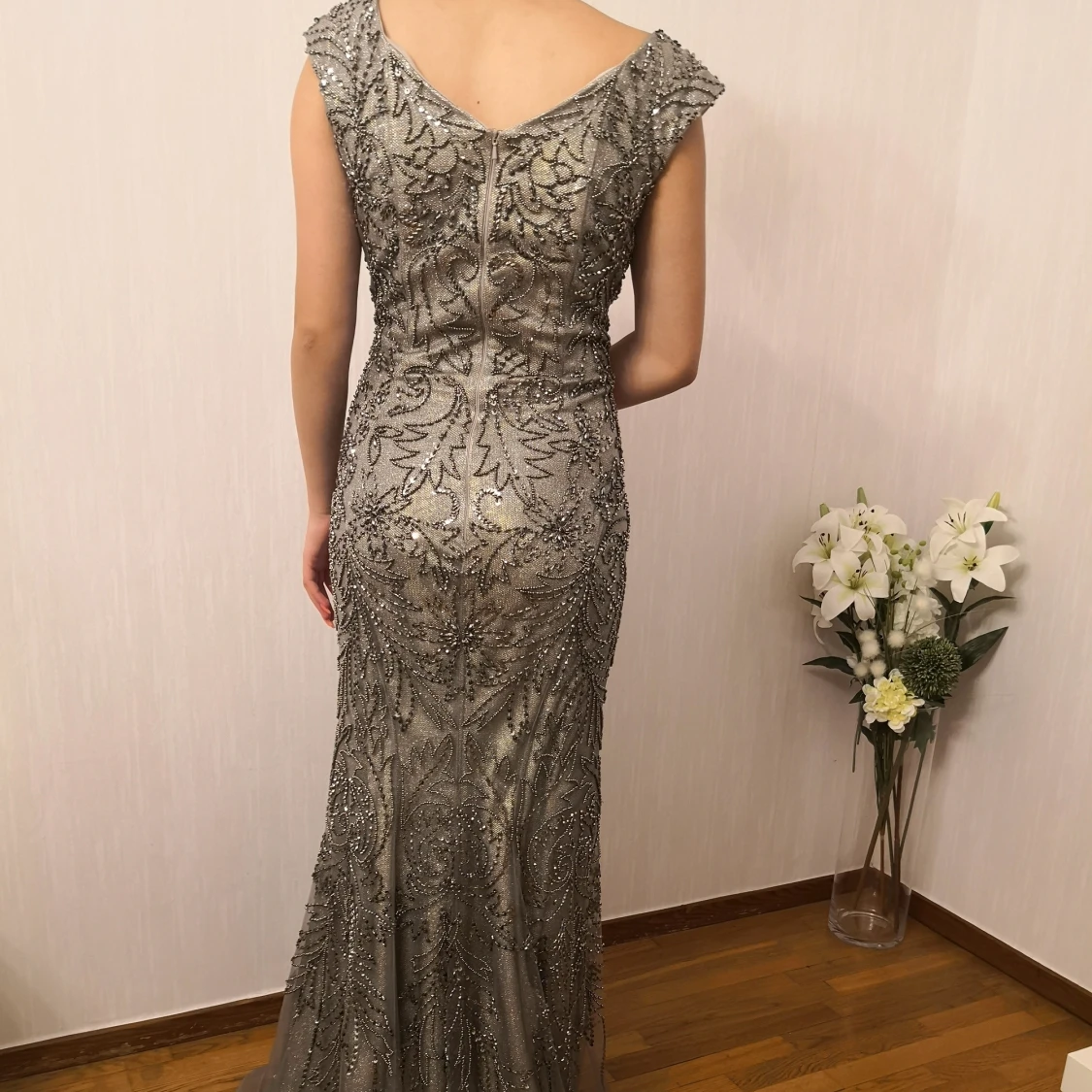 En fin lång klänning i grått och beige med mycket fina detaljer.  - 90