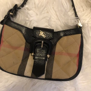 Liten Burberry väska med axelrem - Perfekta modellen att ha i sommar. Rymmer mobil, nycklar, korthållare o smink. 