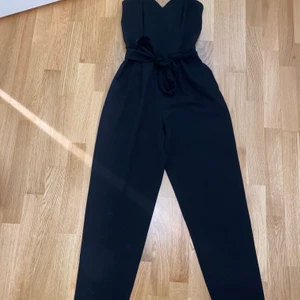 Svart byxdress från H&M - Säljer denna svarta jumpsuite. Super snygg men får inte lika mycket användning av längre. Fortfarande i topp kvalite och är så fin på kroppen! Storlek 34. Bud från 200 kr. Jag står inte för frakt.
