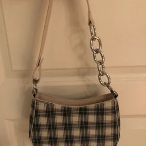 Söt miniväska - Så fin rutig miniväska. Kedjedetalj på ena sidan. 