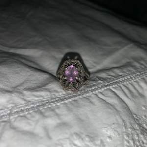 Superfin ring i äkta silver som aldrig kommer till användning längre. Lite mörk silvrig i färgen med en lila sten. 