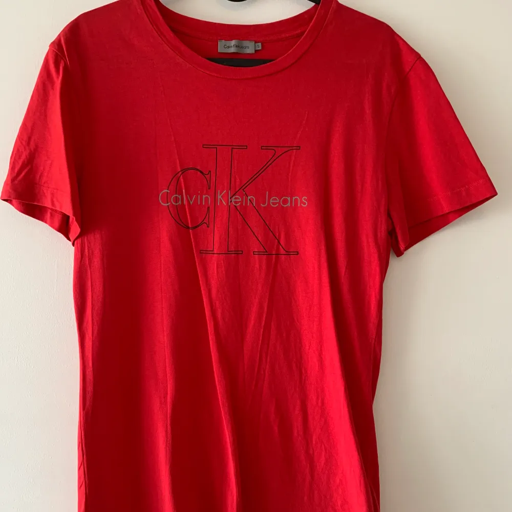 Röd T-shirt från Calvin Klein. Använd ett fåtal gånger och är fortfarande i bra skick.  Storlek s, passar mig som är storlek s/m. Kan mötas upp i Malmö & Vellinge, köparen står för frakten. . T-shirts.