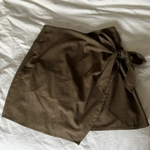 Grön ny omlottkjol - Helt ny mörkgrön/skogsgrön omlottkjol i storlek M, passar S/36 också. Knytning där fram som man kan göra själv, dragkedja i sidan, linnematerial.💖