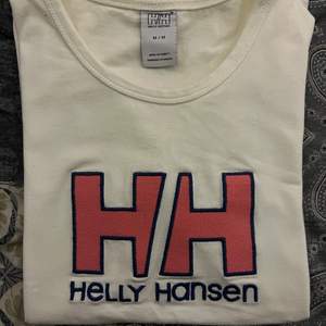 Vit Helly Hansen T-shirt med tryck på framsidan. Aldrig använd då den är för liten. Väldigt mjukt och stretchigt bomullsmaterial. 🖤