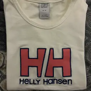 Vit Helly Hansen T-shirt med tryck på framsidan. Aldrig använd då den är för liten. Väldigt mjukt och stretchigt bomullsmaterial. 🖤