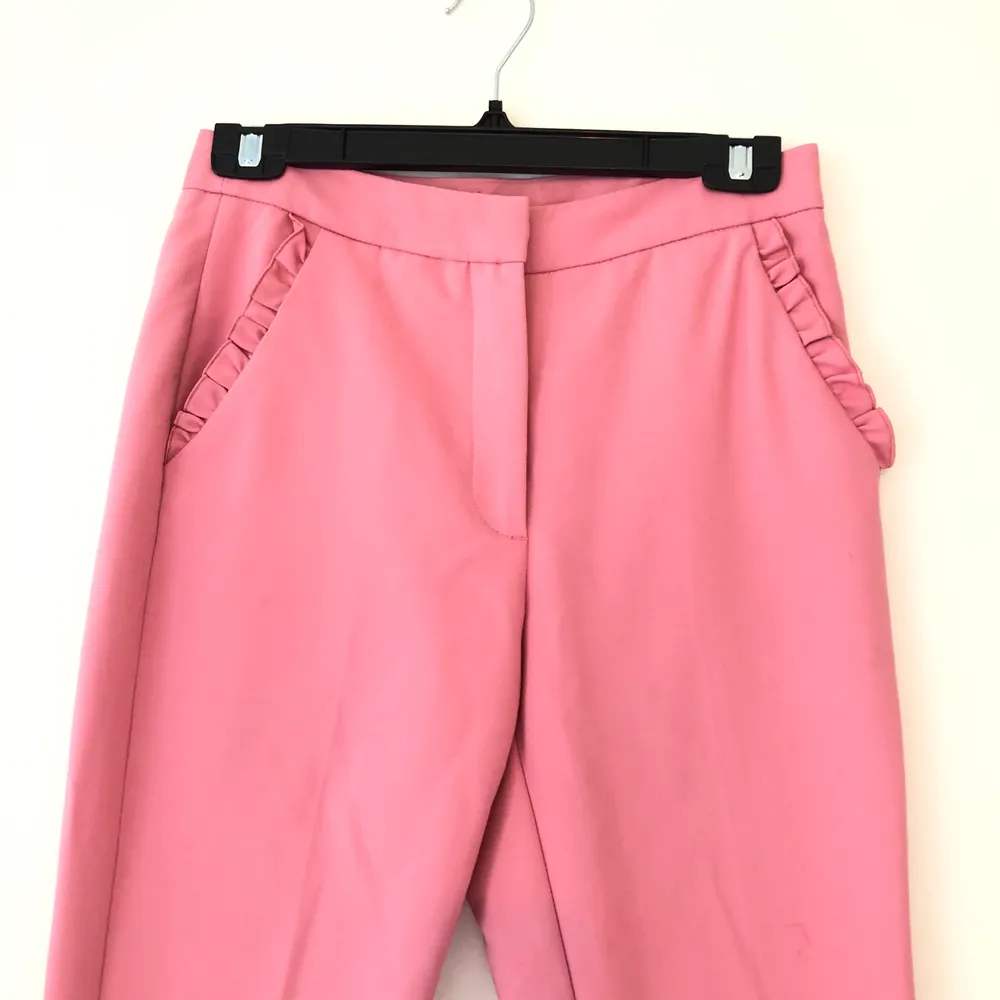 Söta rosa kostymbyxor i strl. s från Zara med volanger på fickorna. I använt men fint skick.. Jeans & Byxor.
